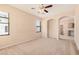 Neutral living room with carpet, ceiling fan, and archway at 6620 Tulip Falls Dr, Henderson, NV 89011