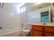 Bright bathroom features a white tile shower-tub combo and wood vanity at 708 Canyon Country Cir, Henderson, NV 89002
