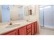 Bathroom featuring double sinks, wood cabinets, and a glass-enclosed shower at 708 Canyon Country Cir, Henderson, NV 89002