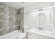 Modern bathroom with bathtub, shower featuring stone-look tile, vanity, and oval mirror at 7139 Mountain Moss Dr, Las Vegas, NV 89147