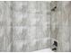 A close-up view of shower walls tiled in stone-look tile with black shower fixture at 7139 Mountain Moss Dr, Las Vegas, NV 89147