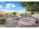Landscaped backyard features a charming spa area with multi-tiered platform, rock detail, and serene desert landscaping at 7183 Majestic Bluff Pl, Las Vegas, NV 89113
