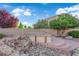Secluded backyard with a rock water feature, landscaping, and built-in hot tub with privacy at 7183 Majestic Bluff Pl, Las Vegas, NV 89113