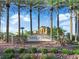Nevada Trails community entrance with stone signage, desert landscaping, and tall palm trees against a blue sky at 7183 Majestic Bluff Pl, Las Vegas, NV 89113