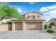 Two story home featuring a three car garage, desert landscaping, and a blue sky background at 7183 Majestic Bluff Pl, Las Vegas, NV 89113