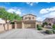 Two story home featuring a three car garage, desert landscaping, and a blue sky background at 7183 Majestic Bluff Pl, Las Vegas, NV 89113