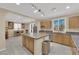 Well-lit kitchen with granite countertops, stainless steel appliances, and an island leading to the dining area at 7183 Majestic Bluff Pl, Las Vegas, NV 89113