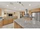 Open kitchen with stainless steel appliances, a granite island, and views into an adjacent living area at 7183 Majestic Bluff Pl, Las Vegas, NV 89113