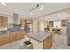 Well-lit kitchen featuring stainless steel appliances, granite countertops, a central island, and an open dining area at 7183 Majestic Bluff Pl, Las Vegas, NV 89113