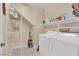 Functional laundry room with a full-size washer and dryer and useful shelving for storage at 7183 Majestic Bluff Pl, Las Vegas, NV 89113