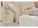 Practical laundry room with appliances, shelving and tile floors at 7183 Majestic Bluff Pl, Las Vegas, NV 89113