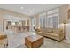 Open-concept living room with tile floors, modern lighting, and comfortable seating area next to an open kitchen at 7183 Majestic Bluff Pl, Las Vegas, NV 89113