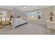 Relaxing primary bedroom with a canopy bed and neutral carpet at 7183 Majestic Bluff Pl, Las Vegas, NV 89113