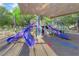 Community playground with multiple slides and playground elements, topped with a sunshade at 7183 Majestic Bluff Pl, Las Vegas, NV 89113