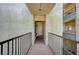 Hallway looking toward the unit entrance, featuring multiple apartments and railing at 7189 S Durango Dr # 208, Las Vegas, NV 89113