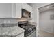 This kitchen features a gas range, granite countertops, and stainless steel microwave at 7189 S Durango Dr # 208, Las Vegas, NV 89113