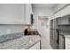 Functional kitchen area featuring stone countertops, essential appliances, and a laundry area, designed for efficiency at 7189 S Durango Dr # 208, Las Vegas, NV 89113