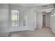 Open living room with tile floors, large windows, and a view into the hallway with a door to the exterior at 7189 S Durango Dr # 208, Las Vegas, NV 89113