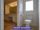 Bright bathroom with vanity, mirror, and modern lighting above the sink with white cabinets and tiled floors at 7365 Mission Hills Dr, Las Vegas, NV 89113