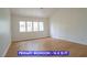 Bright primary bedroom featuring a window and wood-look flooring at 7365 Mission Hills Dr, Las Vegas, NV 89113