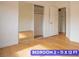 Bright bedroom featuring a closet with mirrored doors and wood-look flooring at 7365 Mission Hills Dr, Las Vegas, NV 89113