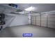 Spacious two car garage featuring ample storage space, painted concrete floors, and utility hookups at 7365 Mission Hills Dr, Las Vegas, NV 89113