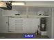 Two car garage with finished concrete floor, overhead storage and utility hookups at 7365 Mission Hills Dr, Las Vegas, NV 89113