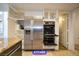 Stainless steel refrigerator and wall oven with granite countertop and white cabinets at 7365 Mission Hills Dr, Las Vegas, NV 89113