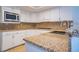 A well-designed kitchen with granite countertops, white cabinetry, and modern stainless appliances at 7365 Mission Hills Dr, Las Vegas, NV 89113