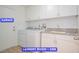 Laundry room with white cabinets, sink, washer, and dryer near garage entrance at 7365 Mission Hills Dr, Las Vegas, NV 89113