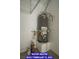 Water heater in garage with sealed concrete floor, painted white walls, and utility hookups at 7365 Mission Hills Dr, Las Vegas, NV 89113