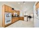 Spacious kitchen featuring light wood cabinets, stainless steel appliances, tile flooring, and vaulted ceilings at 7856 Tolberts Mill Dr, Las Vegas, NV 89131