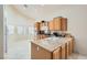 Bright kitchen with granite countertops, light wood cabinetry, stainless steel appliances, and tile flooring at 7856 Tolberts Mill Dr, Las Vegas, NV 89131