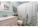 Bright bathroom featuring a vanity, toilet and a bathtub with floral shower curtain at 7904 Seabourn Ct, Las Vegas, NV 89129