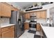 Well-lit kitchen with stainless steel appliances, wood cabinetry, and ample countertop space at 7904 Seabourn Ct, Las Vegas, NV 89129