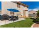 Inviting backyard offers artificial grass, outdoor dining, and a barbeque area for entertaining at 7912 Horn Beam Ct, Las Vegas, NV 89131