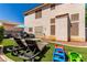 Private backyard with artificial turf, sun loungers, and patio seating for outdoor enjoyment at 7912 Horn Beam Ct, Las Vegas, NV 89131