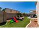 Artificial turf backyard with lounge chairs, outdoor dining, and a secure block wall surround at 7912 Horn Beam Ct, Las Vegas, NV 89131