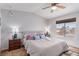 Inviting bedroom featuring a ceiling fan, large window, and plush carpet at 7912 Horn Beam Ct, Las Vegas, NV 89131