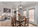 Bright dining room featuring a wooden table, modern light fixture, and a view into the living area at 7912 Horn Beam Ct, Las Vegas, NV 89131