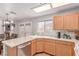 Spacious kitchen with wooden cabinets, stainless steel dishwasher, and view of the dining area at 7912 Horn Beam Ct, Las Vegas, NV 89131