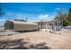 Exterior home view featuring a covered parking structure, desert landscaping, and white exterior at 7960 Quarter Horse Ave, Pahrump, NV 89061