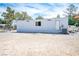 Exterior view featuring a home with neutral siding, windows and a rear door in a desert landscape at 7960 Quarter Horse Ave, Pahrump, NV 89061