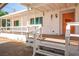 Inviting front porch with a railing and steps leading to an orange front door and desert landscaping at 7960 Quarter Horse Ave, Pahrump, NV 89061