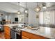 Modern kitchen with a breakfast bar featuring an electric cooktop, oak cabinets, and pendant lighting at 7960 Quarter Horse Ave, Pahrump, NV 89061