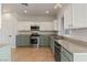 Bright kitchen featuring stainless steel appliances, granite counters, and white and seafoam green cabinetry at 8409 Sherwood Park Dr, Las Vegas, NV 89131