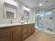 Bathroom featuring a walk-in shower with marble walls and a double vanity at 9369 Villa Ridge Dr, Las Vegas, NV 89134