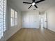 Bright bedroom featuring wood-look floors, a ceiling fan, and shuttered windows at 9369 Villa Ridge Dr, Las Vegas, NV 89134