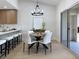 Sunlit dining room featuring modern light fixture, dining set for six, with kitchen bar and access to patio at 9369 Villa Ridge Dr, Las Vegas, NV 89134