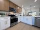 Modern kitchen featuring stainless steel appliances, two-tone cabinetry, and long countertops that looks out to the dining space at 9369 Villa Ridge Dr, Las Vegas, NV 89134